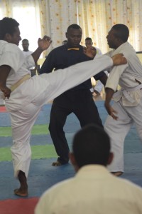 Theophil Meta (left) executing a jodan mawashi geri to his opponent. Picture by Daniel Potuku.